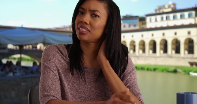 POV shot of black woman on vacation in Florence Italy video calling doctor about neck pain, View from computer screen of woman with medical problem web chatting near the Ponte Vecchio Bridge, 4k