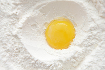 Bright and beautiful egg yolk in wheat flour close-up