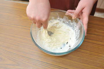 Prepare the dough for a homemade cake, hand knead the dough in a bowl