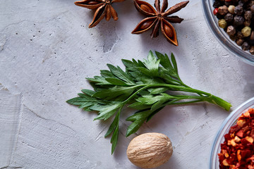 Parsley, nutmeg and anise star on white textured background, top view, close-up, selective focus.