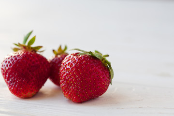 Strawberries ripe on a white wooden background. Copy space. Healthy lifestyle concept