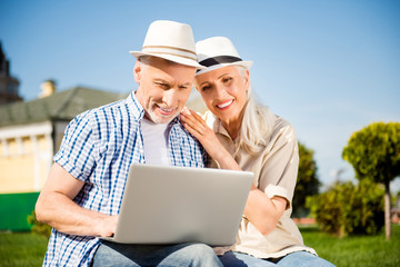 Portrait of lovely attractive spouses having video-call using laptop watching video searching website making online shopping chatting with friends. Apps electronic wireless device concept