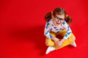 funny child girl in glasses on colored background