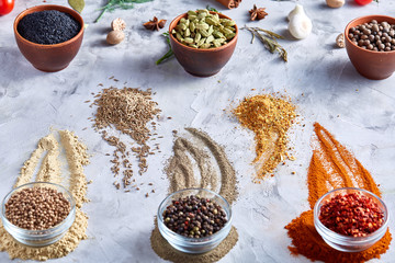 Different bowls with spices arranged in rows on white textured background, view from above.
