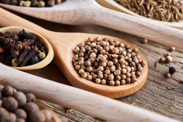 Colourful aromatic various spices for cooking on old wooden barrel, close-up, flat lay, shallow depth of field.