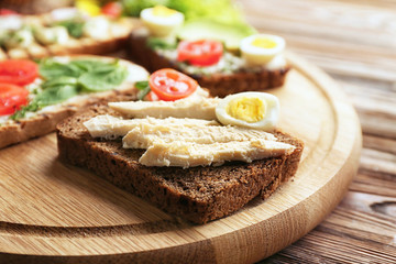 Delicious toasts on wooden table, closeup