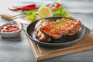 Frying pan with delicious ribs on board