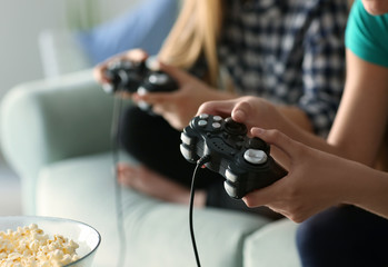 Girls playing video games at home, closeup
