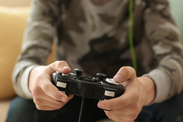 Teenager playing video games at home, closeup