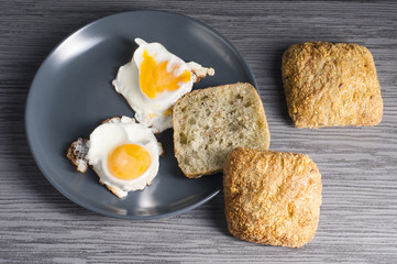 jajka sadzone na talerzu z bułką
