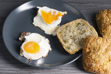 jajka sadzone na talerzu z bułką