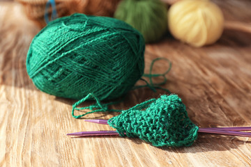 Knitting yarn with needles on wooden table