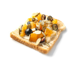 Tasty sweet toast with butter, blueberry, seeds and pieces of fruits on white background