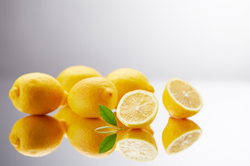 close-up shot of bunch of fresh lemons on reflective surface and on grey