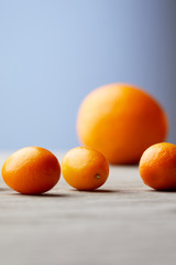 close-up shot of kumquats and orange on wooden surface