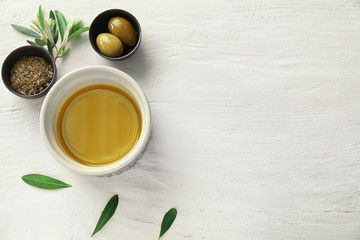 Bowls with oil, olives and spices on white table