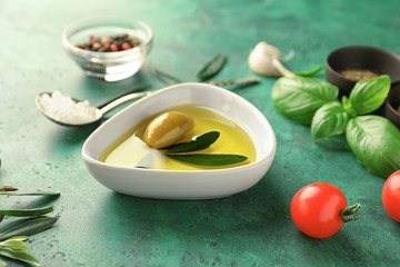 Bowl with fresh olive oil on table