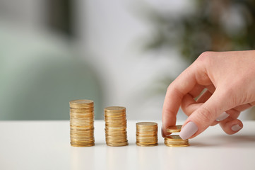 Woman stacking coins on table. Savings concept