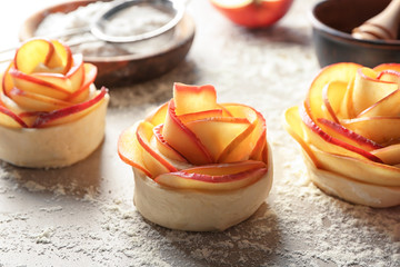 Raw rose shaped apple pastry on table