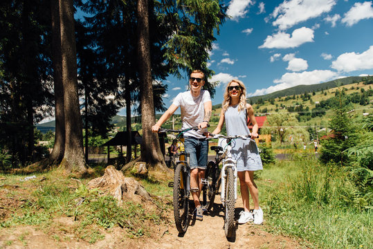 young couple in love ride on bicycles in the mountains