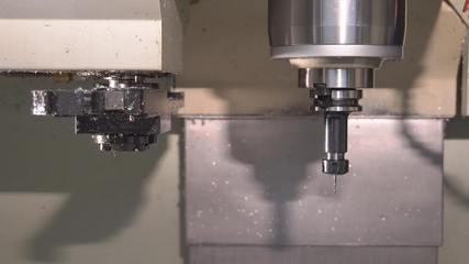 Metalworking at the factory. The computer-controlled machine cuts the part out of aluminum. Machine with program control 4k