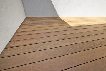 Detail of textured hardwood floor and white ciment wall