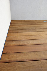 Naklejka na ściany i meble Detail of textured hardwood floor and white ciment wall