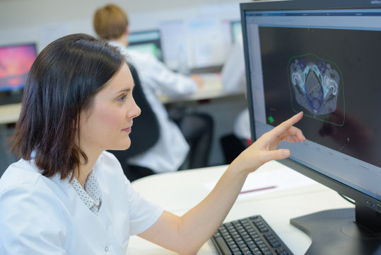 Woman pointing to image on computer screen