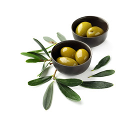 Bowls with oily olives on white background