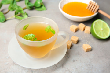 Cup of hot aromatic tea with mint on table