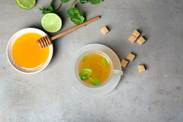 Cup of hot aromatic tea with mint and honey on table