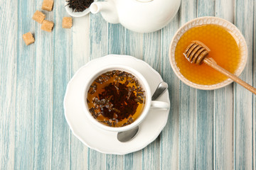 Cup of hot aromatic tea with honey on table