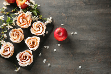 Tasty apple roses from puff pastry on slate plate