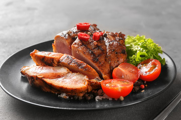 Plate with sliced tasty steak and vegetables on table