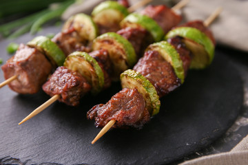 Barbecue skewers with juicy meat and squash on slate plate, closeup