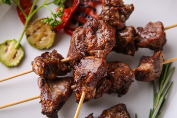 Barbecue skewers with juicy meat on plate