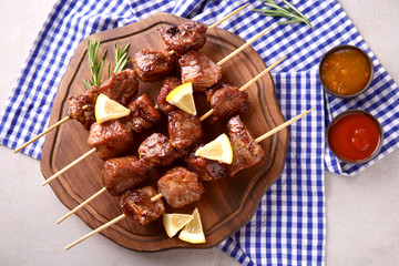 Barbecue skewers with juicy meat on wooden board