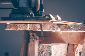 Close-up sawing jigsaw in the board, the process of cutting the board