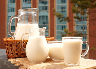 A lot of milk on the windowsill. Milk in jugs and a mug on the balcony sill. Breakfast on the...