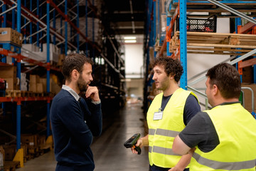 Manager talking with employees in warehouse