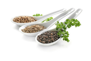 Spoons with various spices on white background