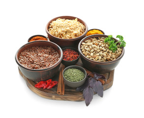 Bowls with various spices on wooden board, isolated on white
