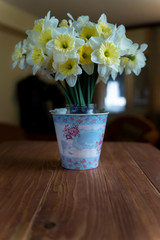 Bouquet of white narcissus flowers on a wooden table at home. Selective focus.