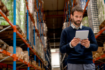 Manager holding digital tablet in warehouse