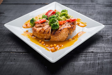 Tasty fried chicken meat with vegetables and lentils sauce on wooden background