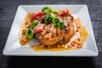 Tasty fried chicken meat with vegetables and lentils sauce on wooden background