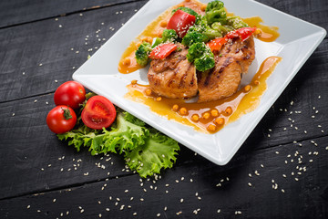 Tasty fried chicken meat with vegetables and lentils sauce on wooden background