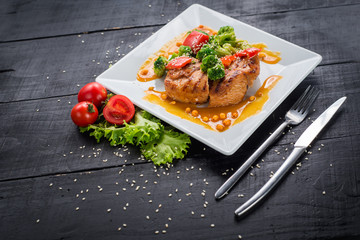 Tasty fried chicken meat with vegetables and lentils sauce on wooden background