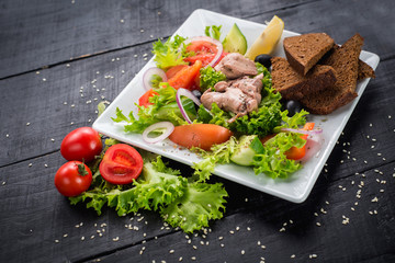 Tasty fried chicken meat with vegetables and lentils sauce on wooden background