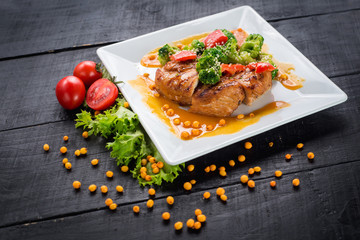 Tasty fried chicken meat with vegetables and lentils sauce on wooden background